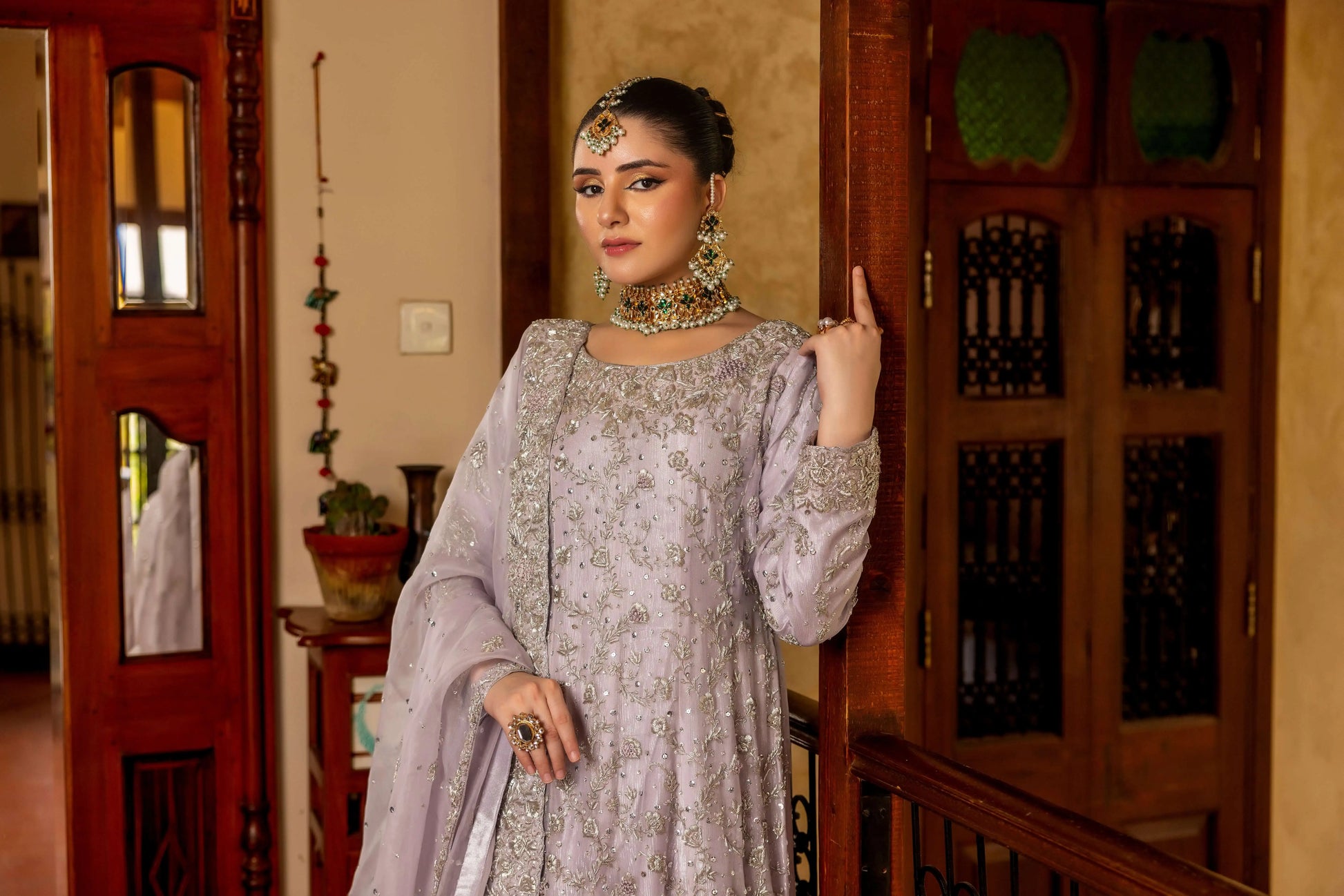 Woman in traditional attire with jewelry indoors