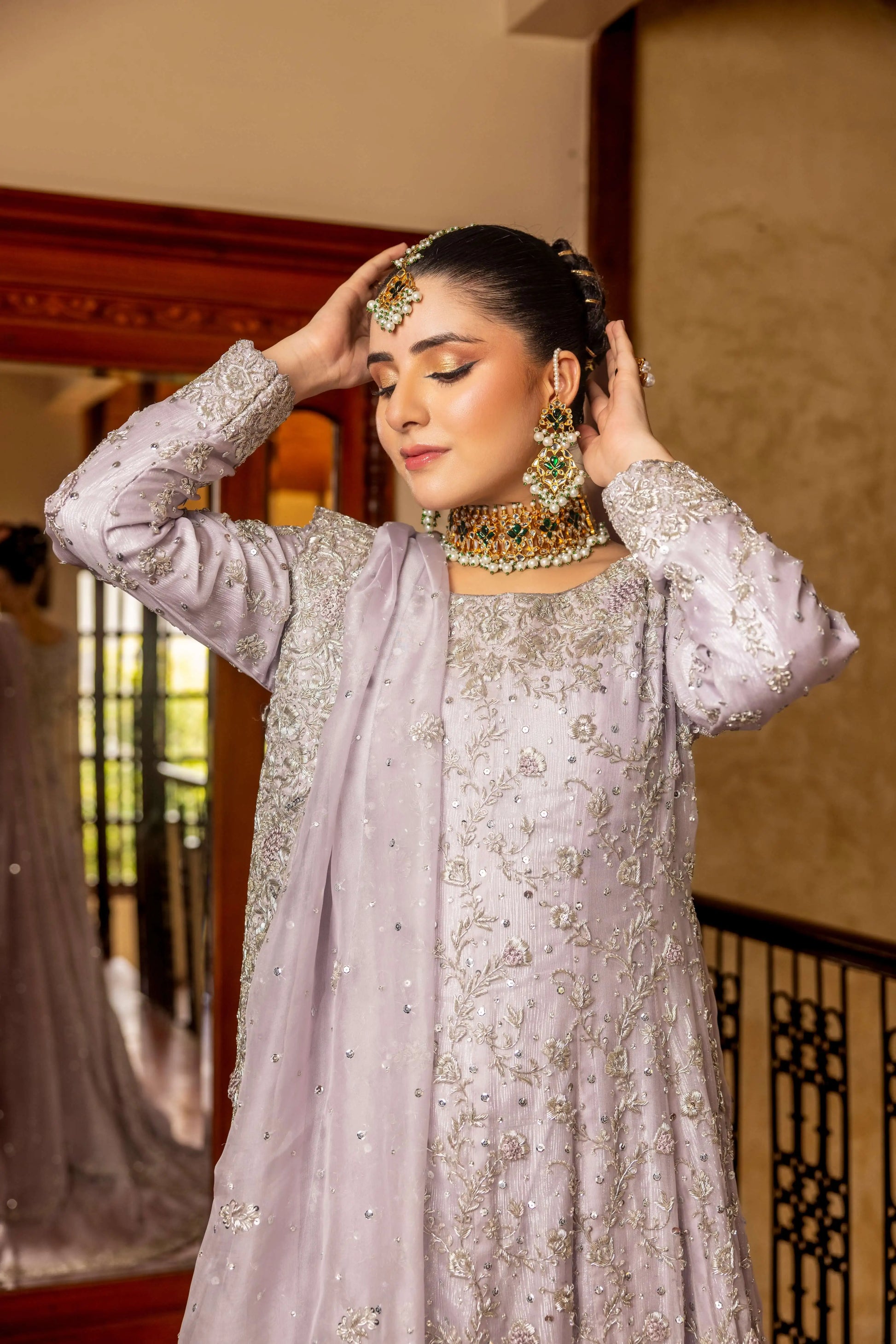 Woman in traditional attire with jewelry indoors