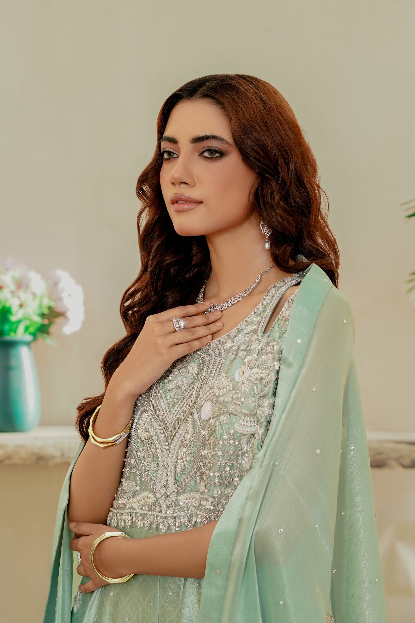 Woman in a light green party wear maxi with silver blouse, posing indoors.