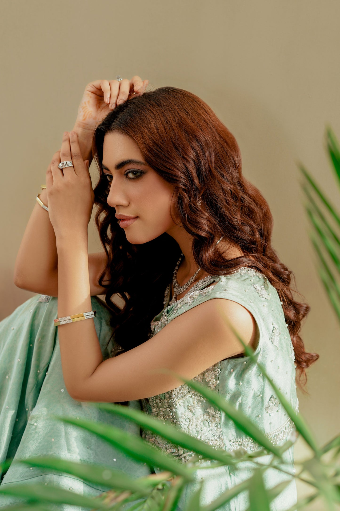 Woman in a light green party wear maxi with a neutral background