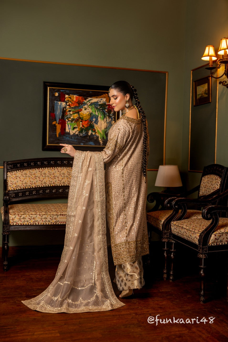 Woman in a traditional wedding formal shirt standing in a room with decorative elements.