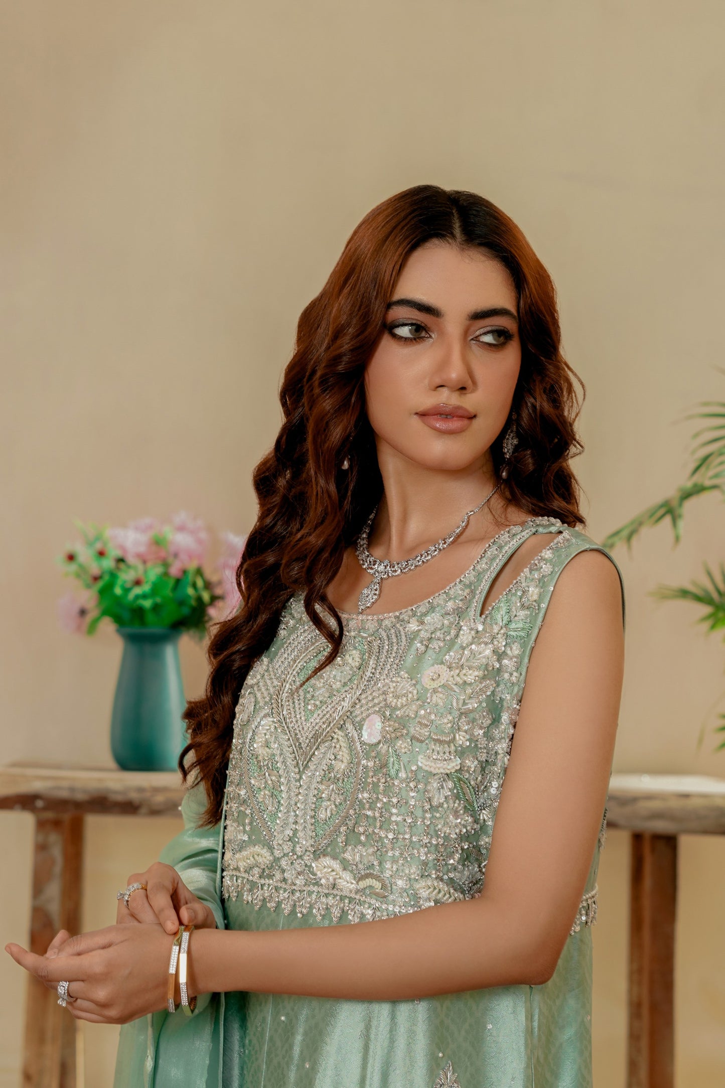 Woman in a light green party wear maxi with floral patterns indoors