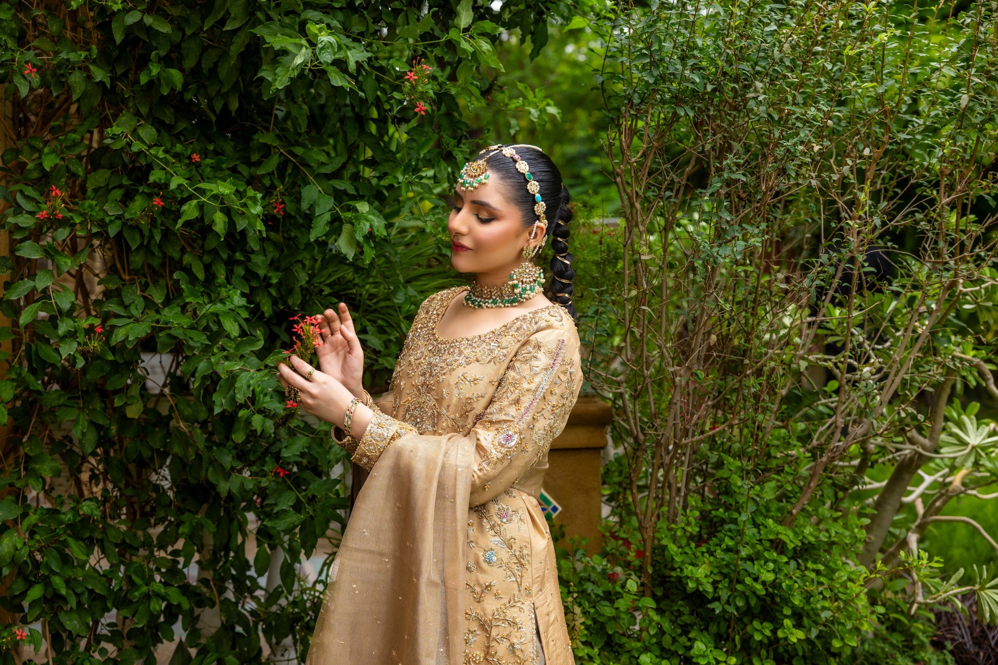 Woman in traditional attire standing in a garden setting