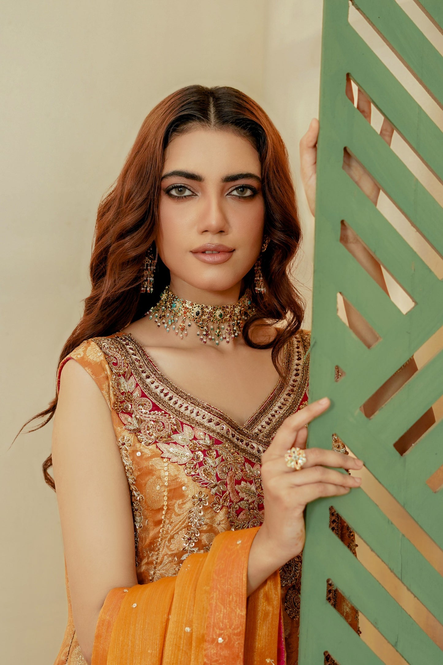 Woman in traditional formal frock attire holding a decorative screen
