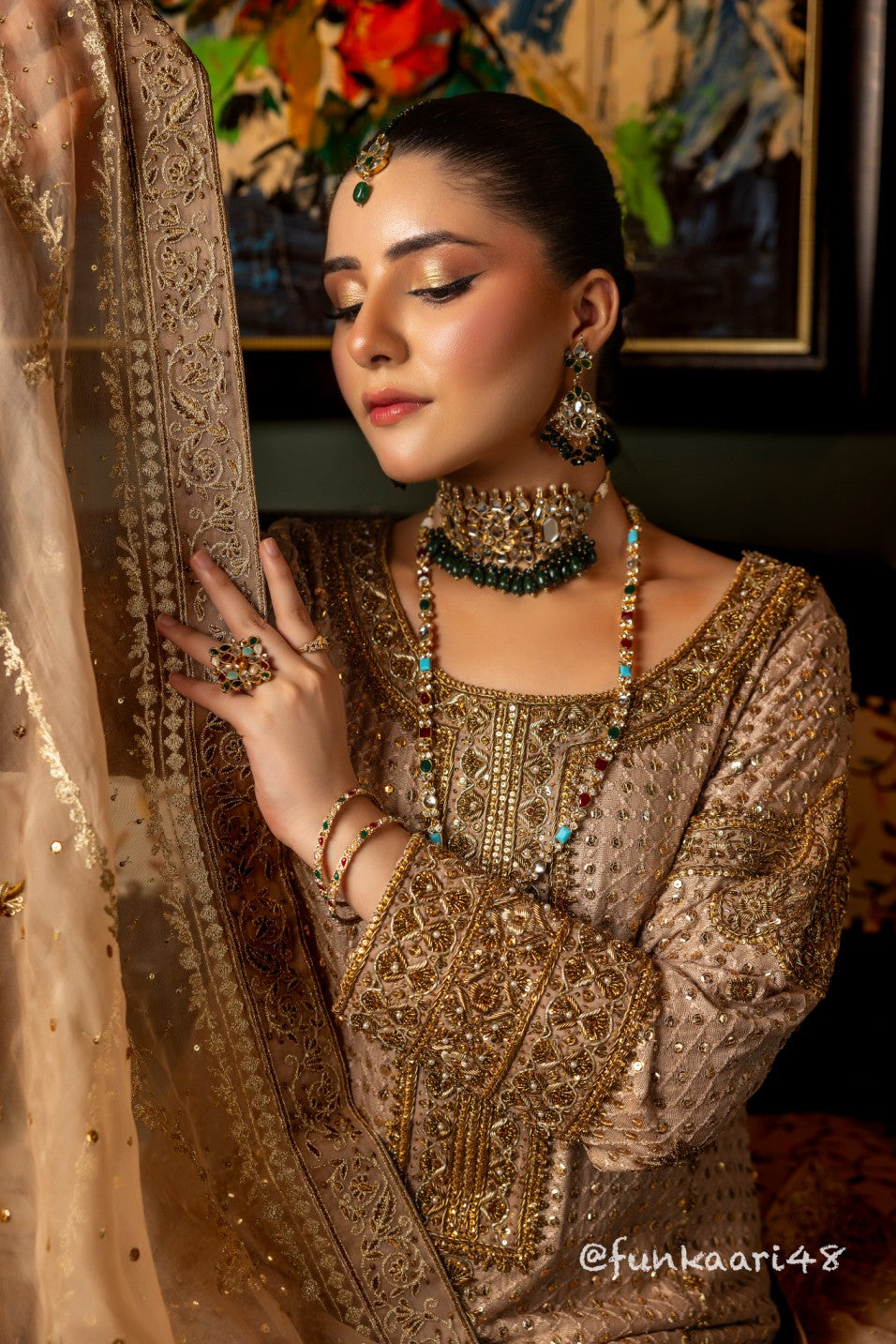 Woman in traditional wedding formal shirt attire with jewelry, posing indoors.