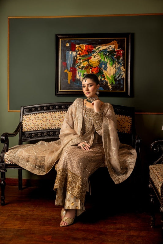 woman in a patterned wedding formal shirt sitting on a bench with a colorful painting in the background