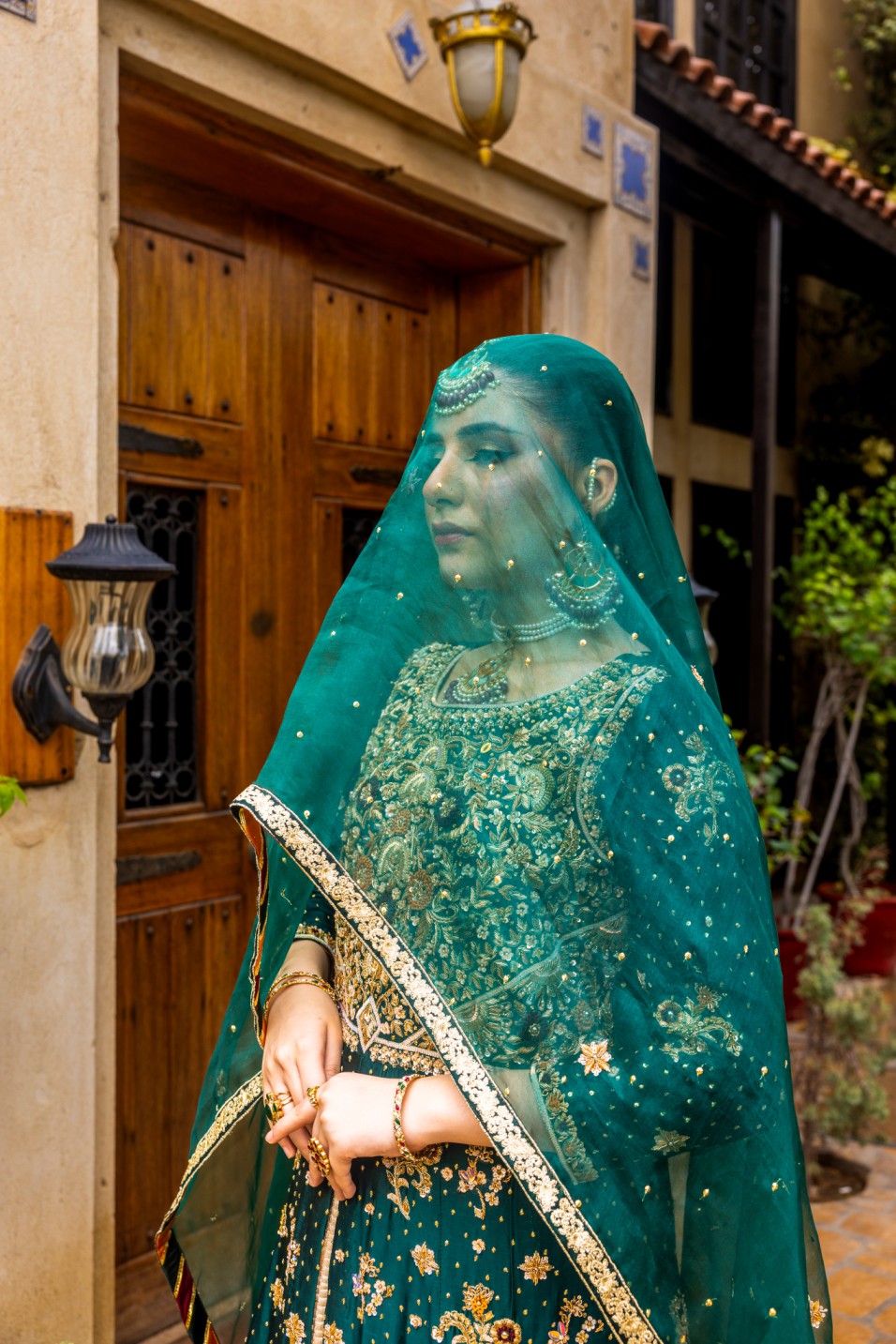 Woman in a traditional green front-open maxi outfit standing outdoors.